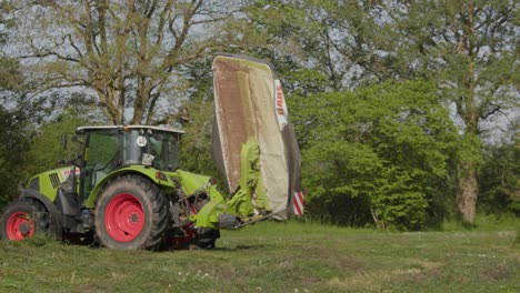 Tractor-Claas-Con-Una-Cortadora-De-Césped-En-El-Campo,-Alejarse,-Vista-Lateral