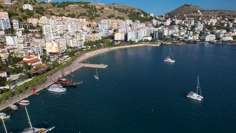 Saranda-Panoramic-Views-of-the-Mediterranean-Bay,-Luxury-Hotels,-Promenade,-Anchored-Boats,-and-Ships-Adorning-the-Azure-Blue-Waters