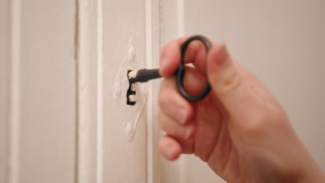 Unlocking-cabinet-with-an-old-aged-key,-closeup