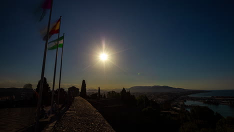 Ein-Heller-Mond-Geht-Auf,-Während-Touristen-Nachts-Das-Castillo-De-Gibralfaro-Besuchen-–-Zeitraffer