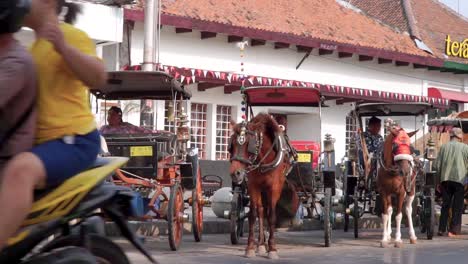 Fila-De-Carruajes-Tirados-Por-Caballos-En-La-Carretera-De-La-Calle-Malioboro,-Yogyakarta---Ambiente-De-La-Calle-Malioboro