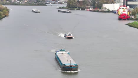 Numerous-cargo-vessels-sailing-on-the-River-Noord,-Ridderkerk,-Netherlands