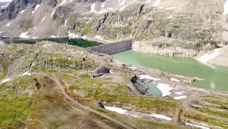 Huge-dam-at-a-lake-surrounded-by-a-rocky-landscape-in-the-Alps-in-Kaernten,-Austria