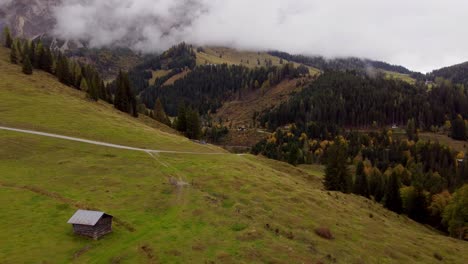Autumn-fall-mountain-landscape-in-Austria-with-wooden-hut-on-green-valley