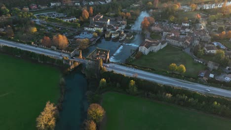 Aerial-Downward-Rotating-Drone-Shot-of-Visconteo's-Bridge-at-Sunset---Borghetto