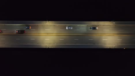 Aerial-shot-of-traffic-on-a-dark-bridge-at-night