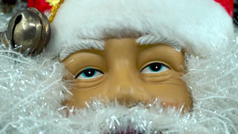 Happy-Santa-Claus-toy-in-a-red-hat-with-bells,-big-white-beard,-Christmas-decoration,-traditional-holiday-presents,-new-year-decor,-shiny-colorful-decor,-creative-close-up-tilt-down-shot,-4K-video
