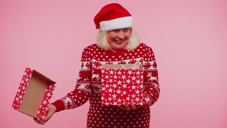 Grandmother-in-Christmas-sweater-smiling,-unwrapping-gift,-opening-box-with-pet-cat,-great-surprise