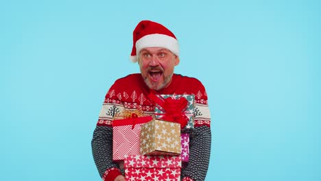 Man-in-Christmas-red-sweater,-Santa-hat,-smiling,-holding-many-gift-boxes-New-Year-presents-shopping