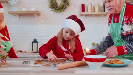 Senior-family-grandparents-with-granddaughter-in-Santa-Claus-hats-preparing,-cooking-homemade-cookie