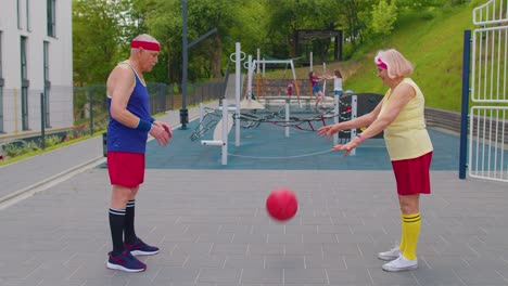 Älteres-Basketballteam-Paar,-Mann-Und-Frau,-Spielt-Mit-Ball,-Passt-Sich-Gegenseitig-Auf-Dem-Stadionplatz-Zu