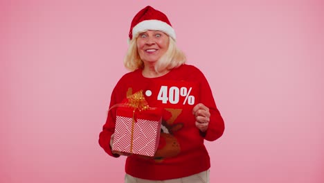 Abuela-En-Suéter-Navideño-Mostrando-Caja-De-Regalo-Y-Texto-De-Banner-De-Inscripciones-Con-40-Por-Ciento-De-Descuento