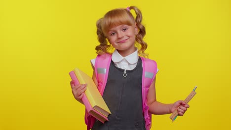 Una-Colegiala-Alegre-Y-Divertida-Con-Libros-Vestida-De-Uniforme-Lleva-Una-Mochila-Sonriendo-Mirando-A-La-Cámara