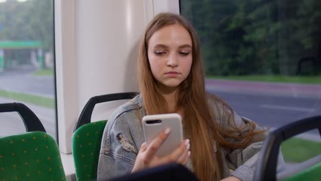 Woman-playing-on-smartphone,-chatting,-texting,-browsing-social-media-while-traveling-by-bus-to-city