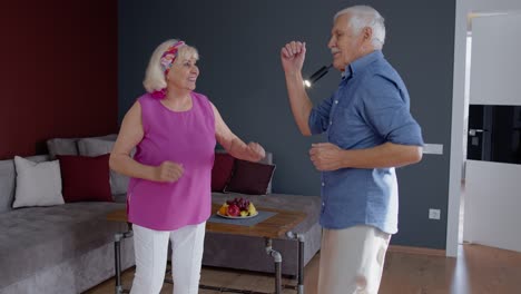 Feliz-Pareja-De-Ancianos-Bailando-Divirtiéndose-Celebrando-El-Aniversario-De-Jubilación-En-El-Salón-De-Casa