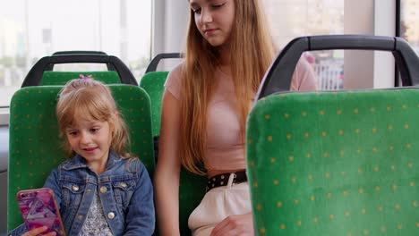 Tired-sleepy-woman-with-daughter-going-home-by-bus-and-fall-asleep,-child-kid-girl-use-mobile-phone