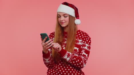 Chica-En-Suéter-Navideño-De-Papá-Noel-Haciendo-Llamadas-De-Teléfono-Móvil-Enviando-Deseos-Felicitar-A-Familiares-Amigos