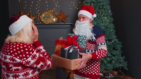 Abuelo-Santa-Claus-Regalando-Caja-De-Regalo-De-Navidad-A-Abuela-Sorprendida,-Familia-De-Pareja-Mayor