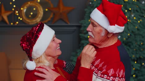 Happy-senior-old-family-couple-grandmother-grandmother-hugging-and-kissing-in-Christmas-home-room