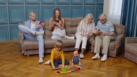 Feliz-Ocio-Familiar-Multigeneracional-En-Casa-Pareja-De-Padres-Y-Abuelos-Relajándose-En-El-Sofá