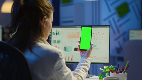 Back-view-of-business-woman-looking-at-smartphone-with-green-screen