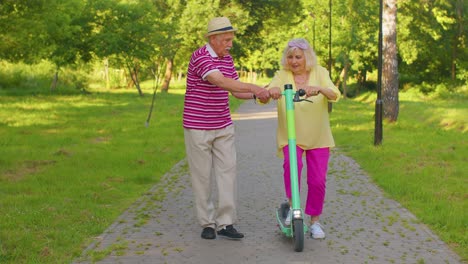 Abuela,-Abuelo-De-Turistas-Mayores-Y-Elegantes-Usando-Scooter-Eléctrico-Mientras-Viajaba-En-El-Parque