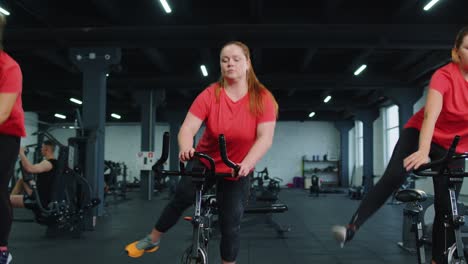 Un-Grupo-De-Chicas-Realiza-Una-Rutina-Cardiovascular-De-Entrenamiento-Aeróbico-En-Simuladores-De-Bicicletas,-Entrenamiento-En-Bicicleta.