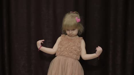 Happy-three-years-old-girl-make-faces-and-dancing.-Cute-blonde-child