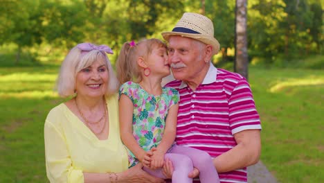 Nieta-Pequeña-Y-Linda-Abrazando-A-Su-Abuela-Y-A-Su-Abuelo,-Pareja-Familiar-En-El-Parque