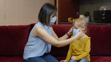 La-Madre-Le-Pone-Una-Máscara-Médica-Protectora-A-Su-Pequeña-Hija-Enferma-En-Casa.-Bloqueo-De-Cuarentena-Por-Coronavirus