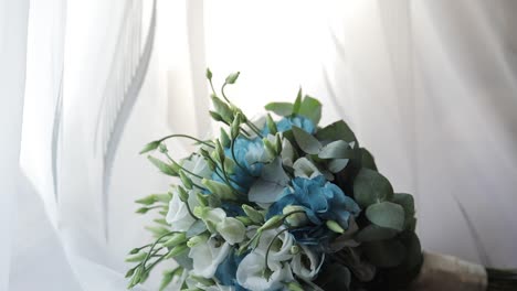 Beautiful-wedding-bouquet-lie-near-window-on-white-curtains