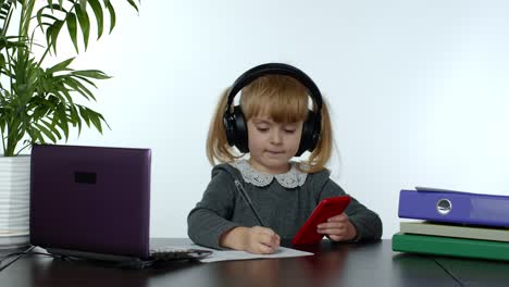 Colegiala-Adolescente-Con-Auriculares-Inalámbricos-Llamando-Al-Profesor-Por-Teléfono-Móvil.-Educación-A-Distancia