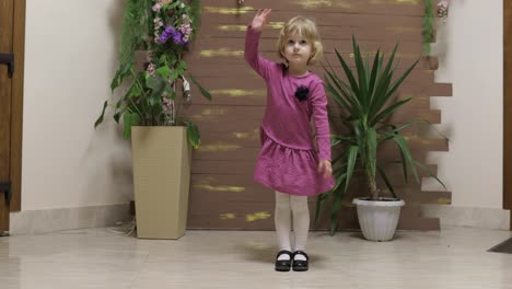 Little-child-dance-near-flowerpots-and-wooden-fence.-Feel-happy,-smiling