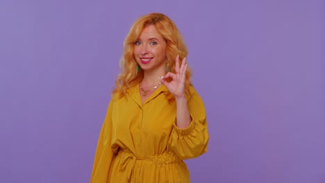 Redhead-girl-looking-approvingly-at-camera-showing-ok-gesture-like-sign-positive-something-good