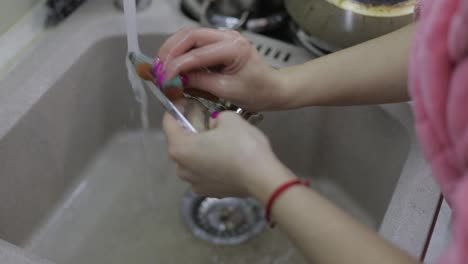 Mujer-Lavando-Platos-En-La-Cocina.-Primer-Plano-De-La-Mano-De-Una-Mujer