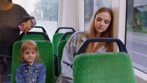 Madre-Exhausta-Se-Queda-Dormida-Y-Pierde-La-Estación-De-Tranvía,-Su-Hija-Despierta-A-Una-Mujer-Cansada-Y-Somnolienta