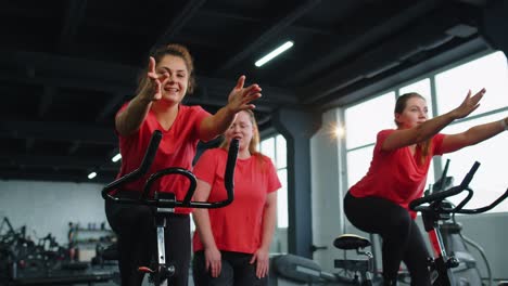 Gesunde-Kaukasische-Gruppe-Von-Frauen-Trainieren-Auf-Einem-Stationären-Fahrrad-Im-Fitnessstudio