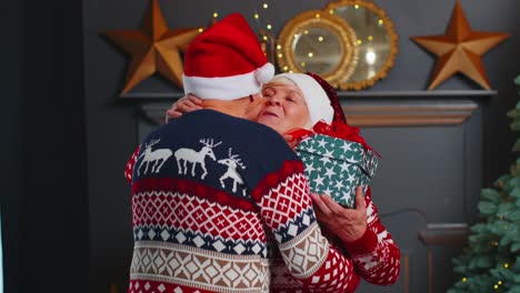 Abuela-De-La-Pareja-De-Ancianos-Presentando-Una-Caja-De-Regalo-De-Navidad-Al-Abuelo-Asombrado-En-La-Habitación-De-Casa