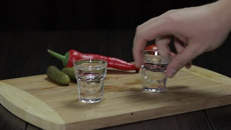 El-Hombre-Toma-Un-Vaso-Lleno-De-Vodka-De-La-Tabla-De-Madera.