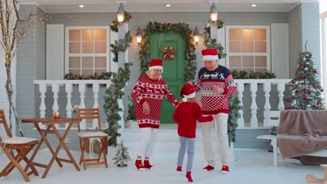 Alegres-Abuelos-Con-Nieta-Niño-Bailando-Alrededor-Del-árbol-Decorado-De-La-Casa-De-Navidad