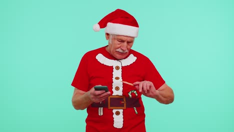 Abuelo-Maduro-De-Navidad-Usa-Teléfono-Celular-Móvil,-Tarjeta-Bancaria-De-Crédito-De-Plástico,-Gana-Calebrate,-Guau