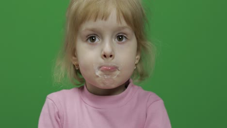 Girl-sitting-at-the-table-and-drinks-yogurt-milk.-Funny-milk-mustache