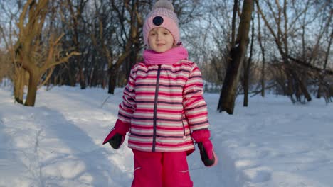 Niño-Sonriente-Caminando,-Divirtiéndose,-Relajándose,-Mirando-Alrededor-En-Un-Camino-Nevado-En-El-Bosque-Del-Parque-Invernal