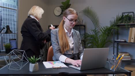 Cunning-young-businesswoman-rubbing-hands-scheming-evil-tricky-prank-plan-in-mind-in-office-interior