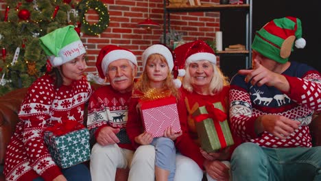 Multigenerational-family-taking-selfie-photo-on-timer-mobile-phone-at-decorated-Christmas-home