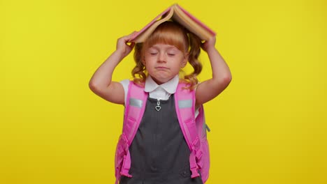 Cheerful-cute-happy-funny-schoolgirl-kid-with-book-on-head,-making-playful-silly-facial-expressions