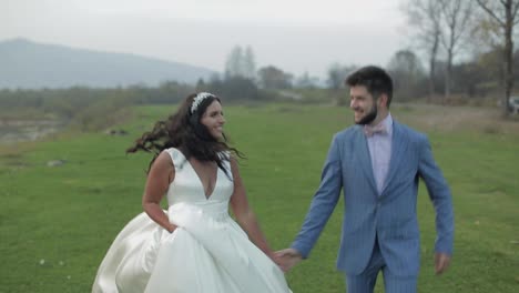 Wedding-couple-running-near-mountain-river.-Groom-and-bride-in-love