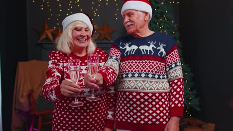 Feliz-Pareja-De-Ancianos-Celebrando-La-Navidad-En-Casa,-Tintineando-Copas-Y-Bebiendo-Champán