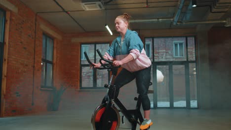 Sportliche-Frau,-Die-Auf-Einem-Stationären-Spinning-Fahrrad-Trainiert,-Im-Fitnessstudio-Trainiert,-Gewichtsverlust-Im-Innenbereich