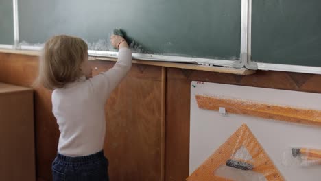 Niña-Limpiando-Pizarra-Usando-Una-Toallita-En-El-Aula.-Proceso-Educativo